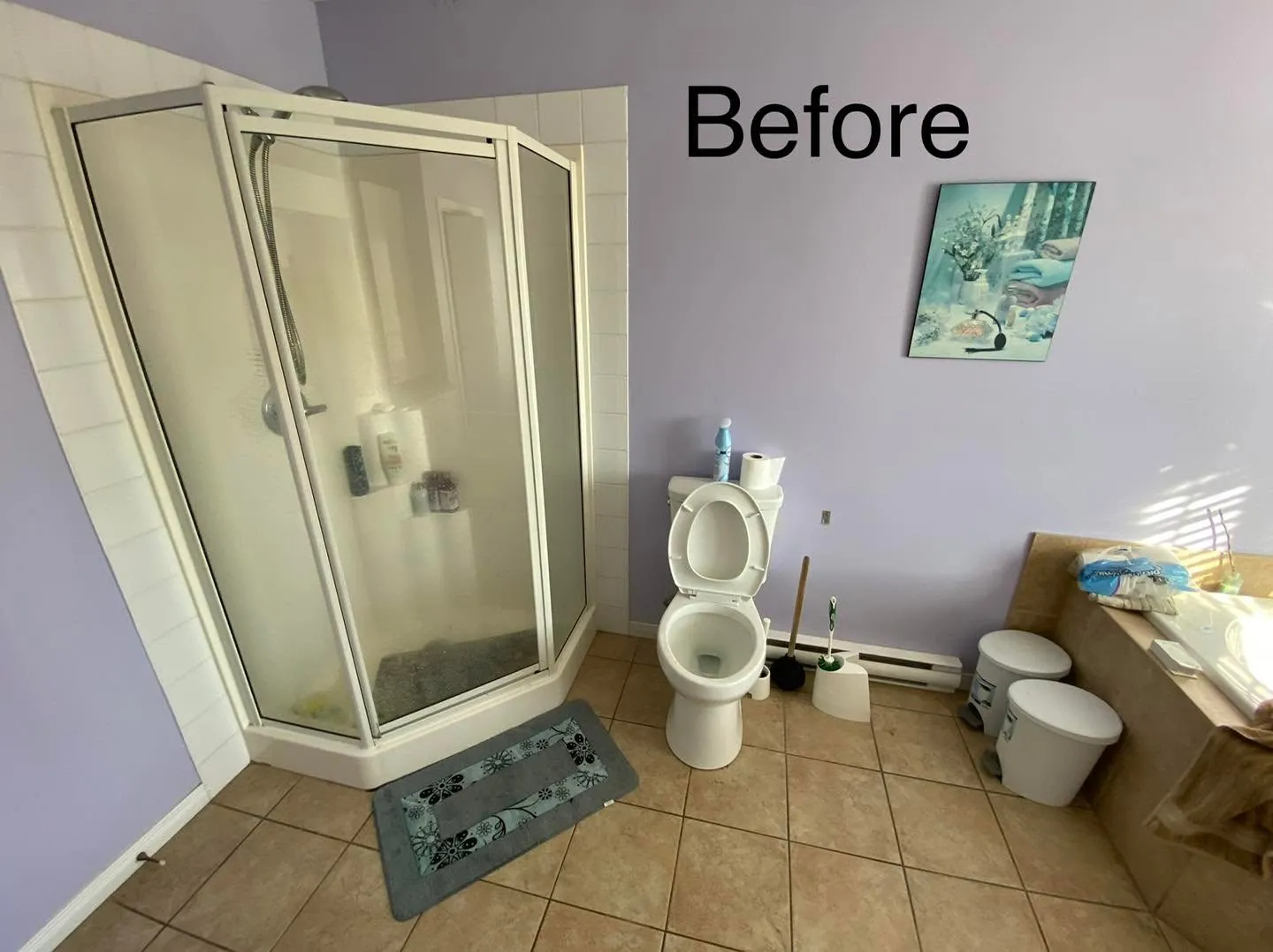 Corner shower with a white framed glass enclosure and tan floor tile